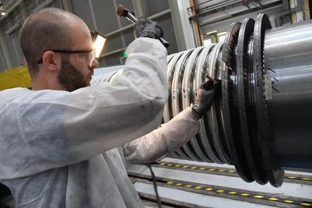 Un operaio al lavoro su parti di una turbina nella fabbrica Ansaldo Energia di Genova, 13 marzo 2018. ANSA/LUCA ZENNARO