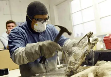 FILE - In this Jan. 9, 2018 file photo, foundry worker Daniel Flores breaks the mold on a solid bronze Actor statuette during the 24th Annual Casting of the Screen Actors Guild Statuette at American Fine Arts Foundry in Burbank, Calif. The SAG Awards will be held on Sunday, Jan. 21 in Los Angeles. (Photo by Chris Pizzello/Invision/ANSA/AP, File) [CopyrightNotice: 2018 Invision]