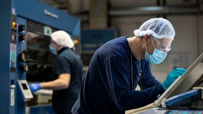 Dipendenti indossano mascherine e guanti protettivi a prevenzione della diffusione del Covid-19, durante il turno di lavoro, presso lo stabilimento industriale di packaging farmaceutico Eurpack di Aprilia, Roma. 21 aprile 2020 ANSA/MASSIMO PERCOSSI