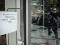 Un cartello esposto su una porta vetrata di un negozio di corso Buenos Aires informa il pubblico della momentanea chiusura dell'esercizio a causa dell'emergenza coronavirus, Milano, 11 marco 2020. In Corso Buenos Aires, un' importante strada commerciale di Milano, che si estendo su oltre 1600 metri con oltre 350 punti vendita di vari tipi di merce e una media di centomila persone ogni giorno, questa mattina metà dei negozi erano chiusi. ANSA/MATTEO CORNER