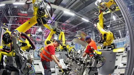 epa03621664 Engineers install a robot at the car body plant of sports car manufacturer Porsche in Leipzig, Germany, 13 March 2013. The small SUV Macan is planned to become the third Porsche model produced in Leipzig towards the end of the year. In the biggest construction project in Porsche's history the plant in Leipzig is currently being expanded for 500 million euros. Porsche is also currently looking for 1,000 new employees for the enlarged plant. EPA/JAN WOITAS