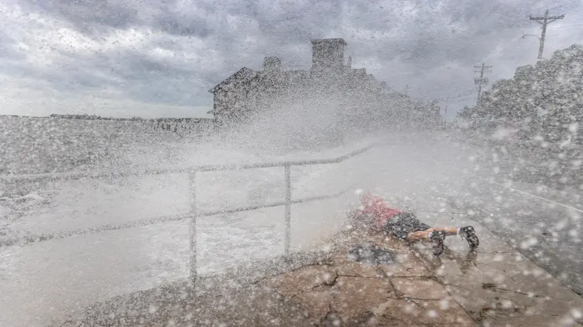 epa11627333 A visitor braves the high surf, storm surge and high winds of Hurricane Helene to take photos at the downtown of Cedar Key, Florida, USA, 26 September 2024. Hurricane Helene is strengthening as it moves toward the U.S. Gulf Coast becoming a Category 1 hurricane and is expected to hit Florida's Big Bend late today as Category 4 storm. Around 32 million people are under flood watches. EPA/CRISTOBAL HERRERA-ULASHKEVICH