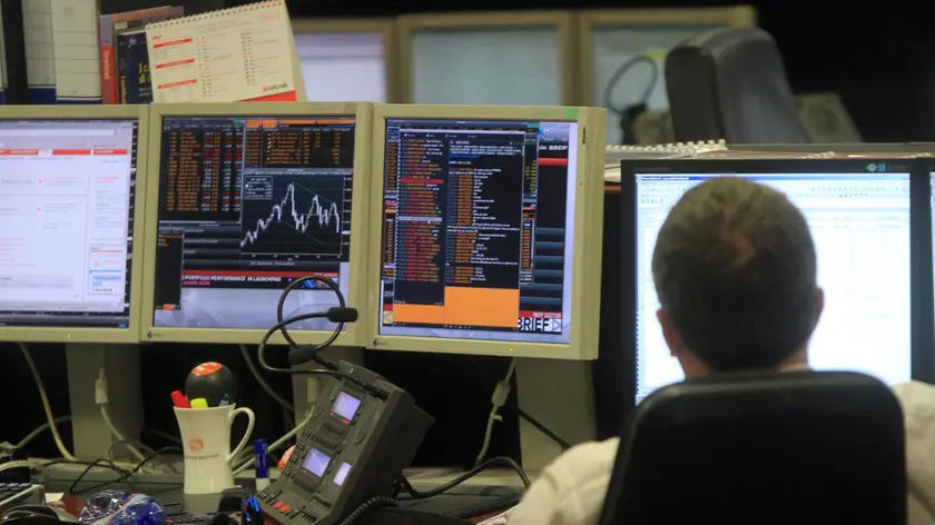 Un broker al lavoro in una sala operativa di una banca milanese oggi, 11 luglio 2011. Piazza Affari, maglia nera in Europa, chiude la seduta poco sopra i minimi con il Ftse Mib in ribasso del 3,96% a 18.295 punti. MATTEO BAZZI / ANSA