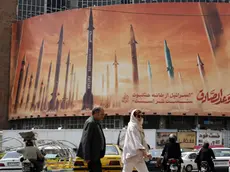 epa11293859 Iranians walk past an anti-Israel billboard carrying pictures of Iranian missiles and a sentence reading in Persian 'Israel is weaker than spider home' in Tehran, Iran, 22 April 2024. Tension between Iran and Israel continue since Iran's Islamic Revolutionary Guards Corps (IRGC) launched drones and missiles towards Israel on 13 April, following an airstrike on the Iranian embassy in Syria which Iran claimed was conducted by Israel. Iranian state media reported that three aerial objects were destroyed by air defense systems over the central city of Isfahan early morning on 19 April. EPA/ABEDIN TAHERKENAREH