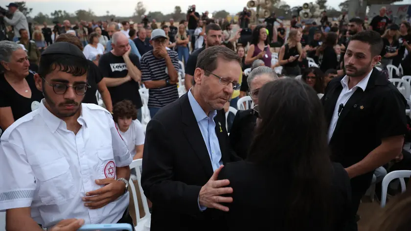 epa11646663 Israeli President Isaac Herzog embraces a family member of victims killed at the Supernova music festival while attending a gathering in memory of their relatives, at the Supernova memorial site for the victims of the 07 October 2023 Supernova music festival attack, near Kibbutz Re'im, close to the border with the Gaza Strip, in southern Israel, 07 October 2024. According to Israeli police, more than 360 Israelis were killed at the SuperNova music festival on 07 October 2023 by Hamas militants that stormed the area during a surprise attack launched from the Gaza Strip. October 07, 2024 marks one year since the Palestinian militant group Hamas launched a surprise attack on Israel, killing 1,400, and one year since Israel began its war on Gaza, killing more than 41,000 and destroying the Palestinian enclave. EPA/ABIR SULTAN