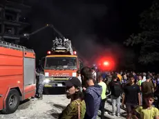 epa11649793 Syrian people stand near fire trucks at the site after missiles fell on a building in the Al-Mazzeh neighborhood in Damascus, Syria, 08 October 2024. At least seven people were killed and 11 others injured after three Israeli missiles targeted a residential building in Damascus, according to Syrian state news agency SANA, adding that rescuers are still working at the site of the strike. Israel did not immediately comment on the strike. EPA/STRINGER