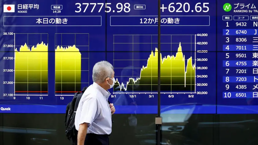 epa11615145 A passerby walks past a stock market indicator board in Tokyo, Japan, 20 September 2024. Tokyo stocks rose following optimism in the US economy and as the Bank of Japan decided to keep its interest rate unchanged after a two-day policy meeting. The 225-issue Nikkei Stock Average gained 568.58 points, or 1.53 percent, to close the week at 37,723.91. EPA/FRANCK ROBICHON