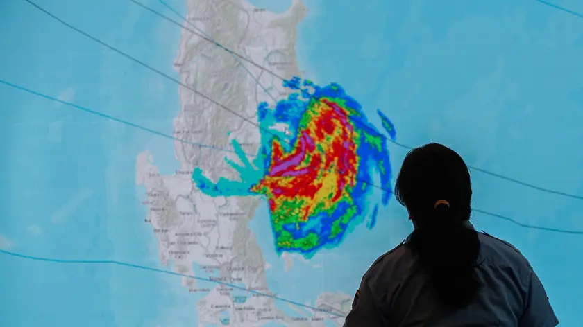 epa11714149 A weather unit supervisor of the Quezon City Disaster Risk Reduction and Management Office (QCDRRMO) looks at an electronic screen projecting the track of Typhoon Toraji at a monitoring center in Quezon City, Metro Manila, Philippines, 11 November 2024. Schools in Metro Manila suspended classes, and citizens were reminded to take necessary precautions as Typhoon Toraji struck the Northern Luzon region, bringing heavy rain and sustaining winds of 130 kilometers per hour. EPA/ROLEX DELA PENA