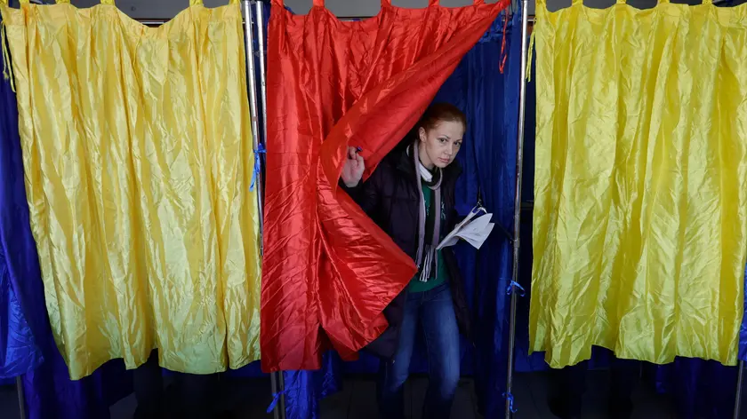epa11738376 A Romanian woman exits the voting booth after stamping her ballot while voting for the first round of presidential elections at 'Cezar Bolliac' School polling station in Bucharest, Romania, 24 November 2024. Marcel Ciolacu, leader of the Social Democratic Party (PSD) and incumbent prime minister, still leads in the presidential race according to the latest vote intention surveys, followed by Alliance for the Union of Romanians (AUR) leader George Simion, and Save Romania Union (USR) candidate Elena Lasconi. Romanians vote today for ninth presidential election, with a second round planned for 08 December 2024. Approximately 18 million Romanian citizens are expected at the polling stations this weekend, according to the Permanent Electoral Authority (AEP), of which 989,230 people can express their intention abroad. EPA/ROBERT GHEMENT
