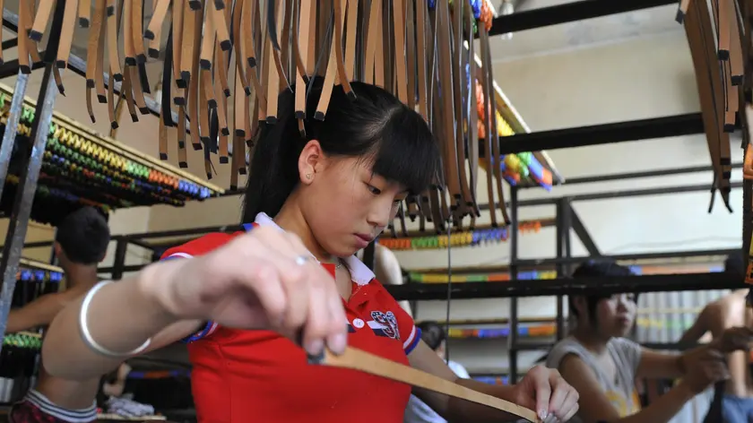 epa02334738 A young worker dyes leather materials at a luggage workshop in Baigou town of Gaobeidian city, China's Hebei province,13 September 2010. Baigou town, about 100 km south of China's capital Beijing, is one of the biggest bags and luggages production bases and wholesale markets in China. The bags and luggages industry drives the surrounding counties and cities in more than 55 townships; more than 30 million people work in this industry. More than 10,000 manufacturers and workshops produced more than 650 million bags and luggages products with a transaction amount of 31.26 billion yuan (Euro 3.58 billion) in 2009. EPA/WU HONG