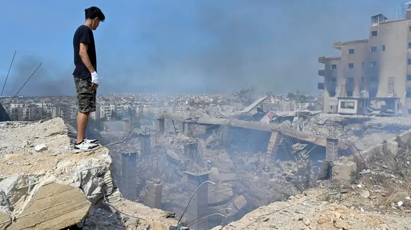 Un uomo sull’orlo di una voragine dopo un bombardamento israeliano a Choueifat, sud est di Beirut, Libano (LIBRO PHOTOANSA24 - EPA/WAEL HAMZEH)