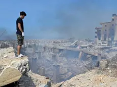 Un uomo sull’orlo di una voragine dopo un bombardamento israeliano a Choueifat, sud est di Beirut, Libano (LIBRO PHOTOANSA24 - EPA/WAEL HAMZEH)