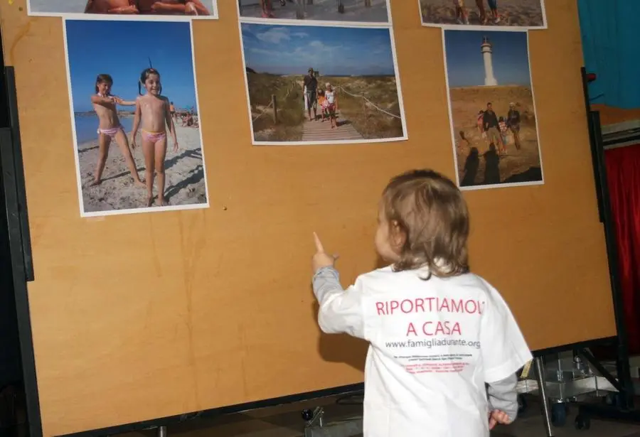 Una bimba con la maglietta "Riportiamoli a casa" durante un evento in memoria della famiglia Durante