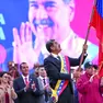 Il presidente Nicolas Maduro sventola la bandiera nazionale sul palco di una manifestazione a Caracas