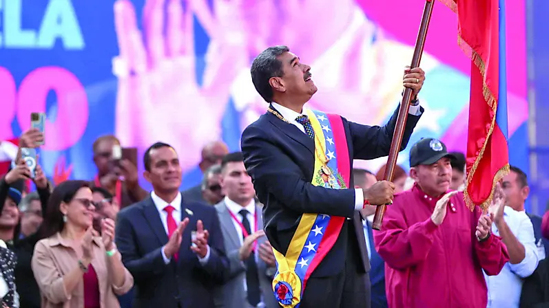 Il presidente Nicolas Maduro sventola la bandiera nazionale sul palco di una manifestazione a Caracas