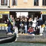 Turisti accalcati alla fermata di vaporetto per fotografare il corteo acqueo del Carnevale