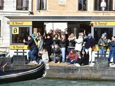 Turisti accalcati alla fermata di vaporetto per fotografare il corteo acqueo del Carnevale