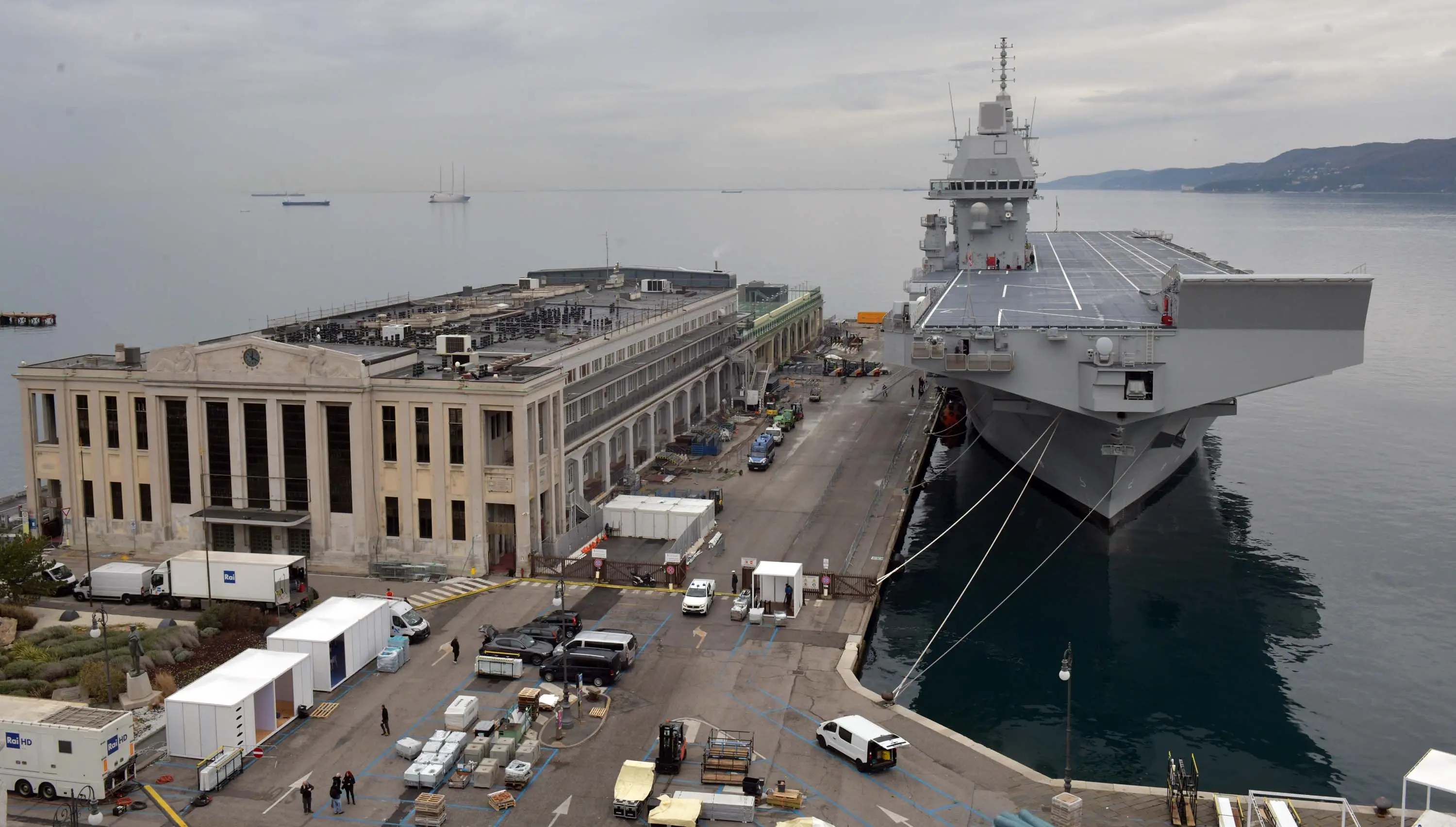 Immaginate un bacino a secco grande come una piscina olimpionica, con la capacità di ospitare i più avanzati mezzi militari su terra e acqua. Poi un ponte di volo, sul quale possono atterrare elicotteri ma anche F-35, che hanno a disposizione un hangar da oltre 2 mila metri quadrati. Aggiungetevi quindi un ospedale con sale per la tac, laboratori d’analisi, terapie intensive, isole neonatali e reparti odontoiatrici. Infine tre cannoni e altrettante mitragliatrici, cabine letto e sistemi di difesa all’avanguardia. Ora un ultimo sforzo: comprimete tutto in un unico spazio lungo 245 metri, largo 47 e alto come un edificio di circa dieci piani. E non scordatevi che deve muoversi in mare, anche con una certa agilità. Siamo a bordo di Nave Trieste, la più grande unità mai costruita per la Marina Militare dalla cantieristica italiana. Ha attraccato alla Stazione marittima di Trieste martedì pomeriggio per l'arrivo, sabato primo maggio, del Vespucci: si può visitare gratuitamente. Qui l'articolo e qui le foto di Francesco Bruni