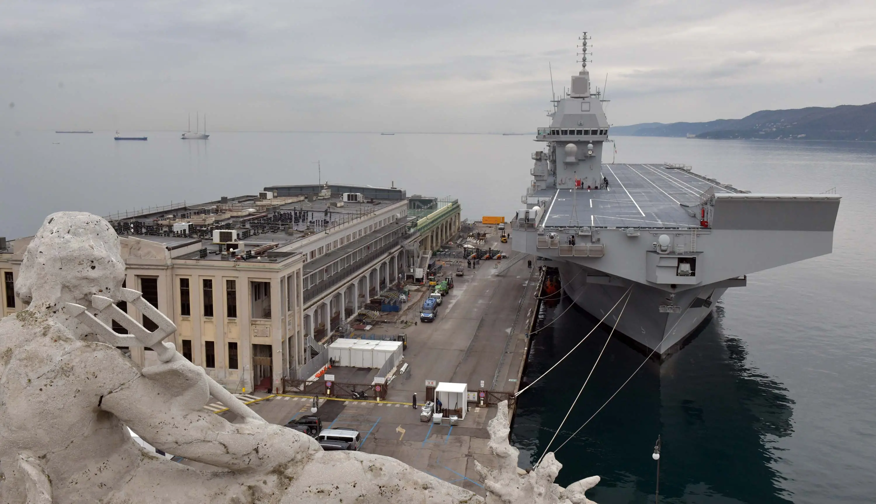 Immaginate un bacino a secco grande come una piscina olimpionica, con la capacità di ospitare i più avanzati mezzi militari su terra e acqua. Poi un ponte di volo, sul quale possono atterrare elicotteri ma anche F-35, che hanno a disposizione un hangar da oltre 2 mila metri quadrati. Aggiungetevi quindi un ospedale con sale per la tac, laboratori d’analisi, terapie intensive, isole neonatali e reparti odontoiatrici. Infine tre cannoni e altrettante mitragliatrici, cabine letto e sistemi di difesa all’avanguardia. Ora un ultimo sforzo: comprimete tutto in un unico spazio lungo 245 metri, largo 47 e alto come un edificio di circa dieci piani. E non scordatevi che deve muoversi in mare, anche con una certa agilità. Siamo a bordo di Nave Trieste, la più grande unità mai costruita per la Marina Militare dalla cantieristica italiana. Ha attraccato alla Stazione marittima di Trieste martedì pomeriggio per l'arrivo, sabato primo maggio, del Vespucci: si può visitare gratuitamente. Qui l'articolo e qui le foto di Francesco Bruni