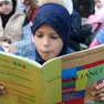 Una bambina legge un libro di testo italiano in una foto d'archivio