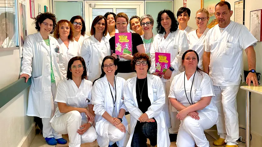 Elisa Sommavilla al centro con il suo libro "Storia di una cellula impazzita" assieme al personale dell'ospedale di San Bonifacio, nel Veronese