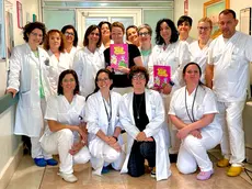 Elisa Sommavilla al centro con il suo libro "Storia di una cellula impazzita" assieme al personale dell'ospedale di San Bonifacio, nel Veronese