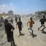 Civili corrono al riparo dopo un attacco aereo israeliano a ovest di Gaza City