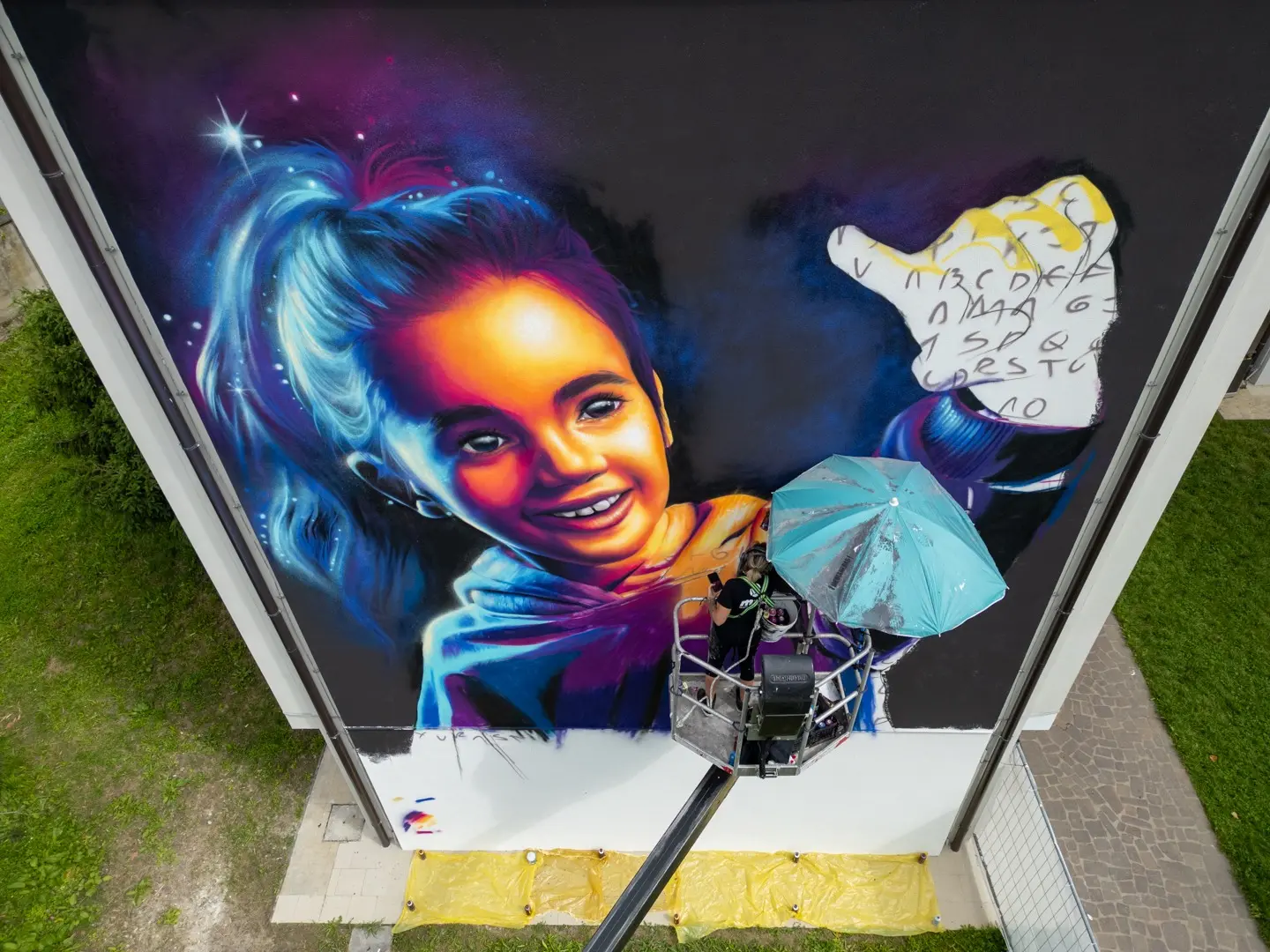 L’artista polacca Sikowska al lavoro sul muro dell’Ic Tommaseo