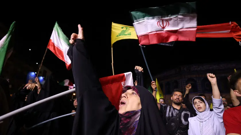 La bandiere iraniani sventolano nelle strade di Teheran dopo la reazione del regime all'attacco israeliano
