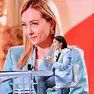 Nella foto Elly Schlein, sullo sfondo un’immagine della Meloni