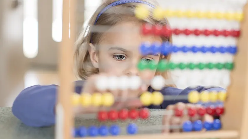 Una bimba alle prese con una lezione di matematica