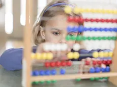 Una bimba alle prese con una lezione di matematica