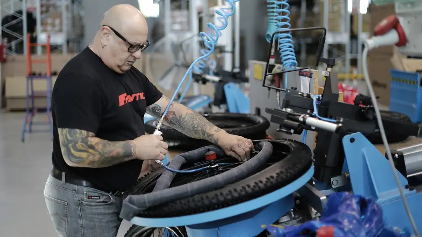 Un operaio al lavoro su una linea di produzione di bici della Fantic