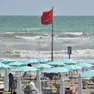 Bandiera rossa in spiaggia, metafora di un’estate politica tutt’altro che tranquilla