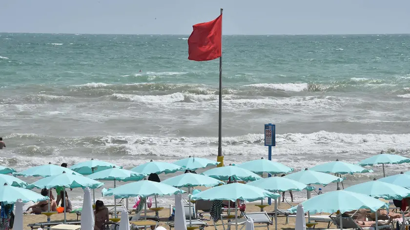 Bandiera rossa in spiaggia, metafora di un’estate politica tutt’altro che tranquilla
