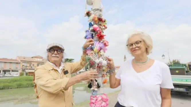 In foto Giorgio Cavicchio insieme a Ana Simona Bevevz intorno al palo della luce diventato luogo per il toys crossing