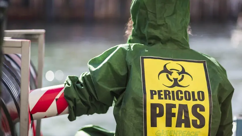 Un’attivista di Greenpeace durante una protesta anti Pfas. Foto Ansa