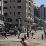 Palestinesi in strada dopo un attacco aereo di Israele a un edificio residenziale di Gaza City