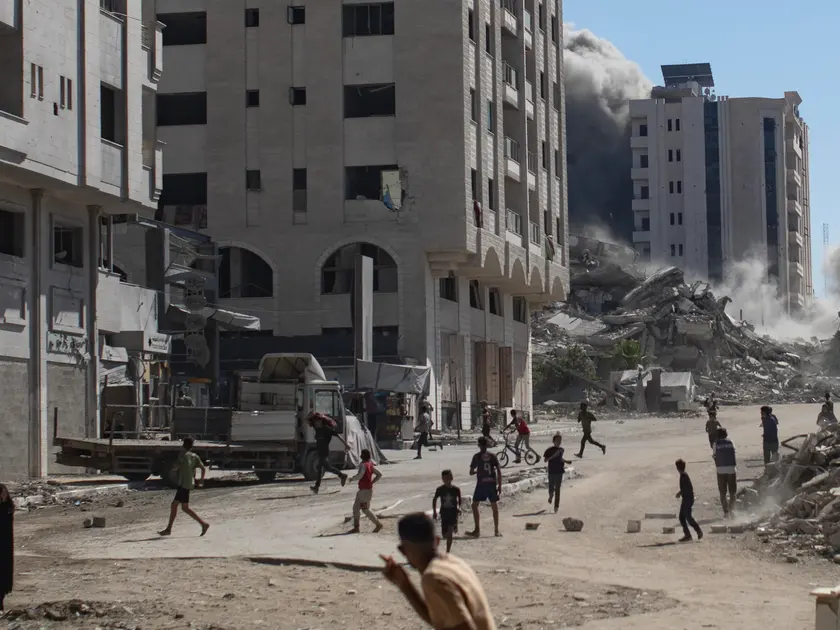 Palestinesi in strada dopo un attacco aereo di Israele a un edificio residenziale di Gaza City