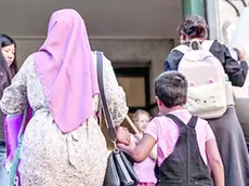 Una mamma musulmana che accompagna la propria figlia a scuola
