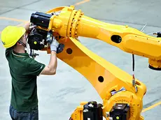 Un operaio assembla un robot industriale. L’industria cinese si è reinventata investendo sull’hi-tech