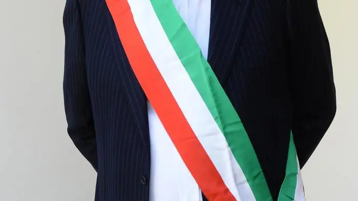 Un sindaco indossa la fascia tricolore