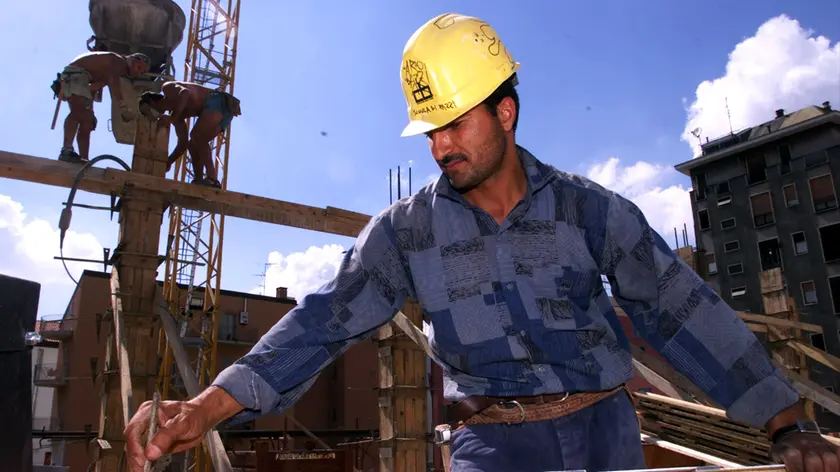 Un operaio egiziano al lavoro in un cantiere nel centro di Milano in un'immagine d'archivio del luglio 2000.