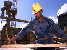 Un operaio egiziano al lavoro in un cantiere nel centro di Milano in un'immagine d'archivio del luglio 2000.