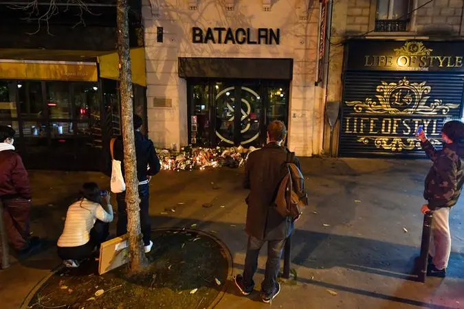Davanti al Bataclan aumentano i fiori e i passanti che si fermano in silenzio