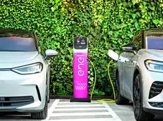 Due auto elettriche ferme parcheggiate ad una colonnina per ricaricare la batteria