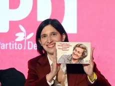 La segretaria del Pd Elly Schlein mostra la tessera 2026 del partito dedicata a Tina Anselmi