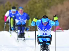 Giuseppe Romele in azione in una gara di sci di fondo paralimpico, nel riquadro Marco Giunio De Sanctis