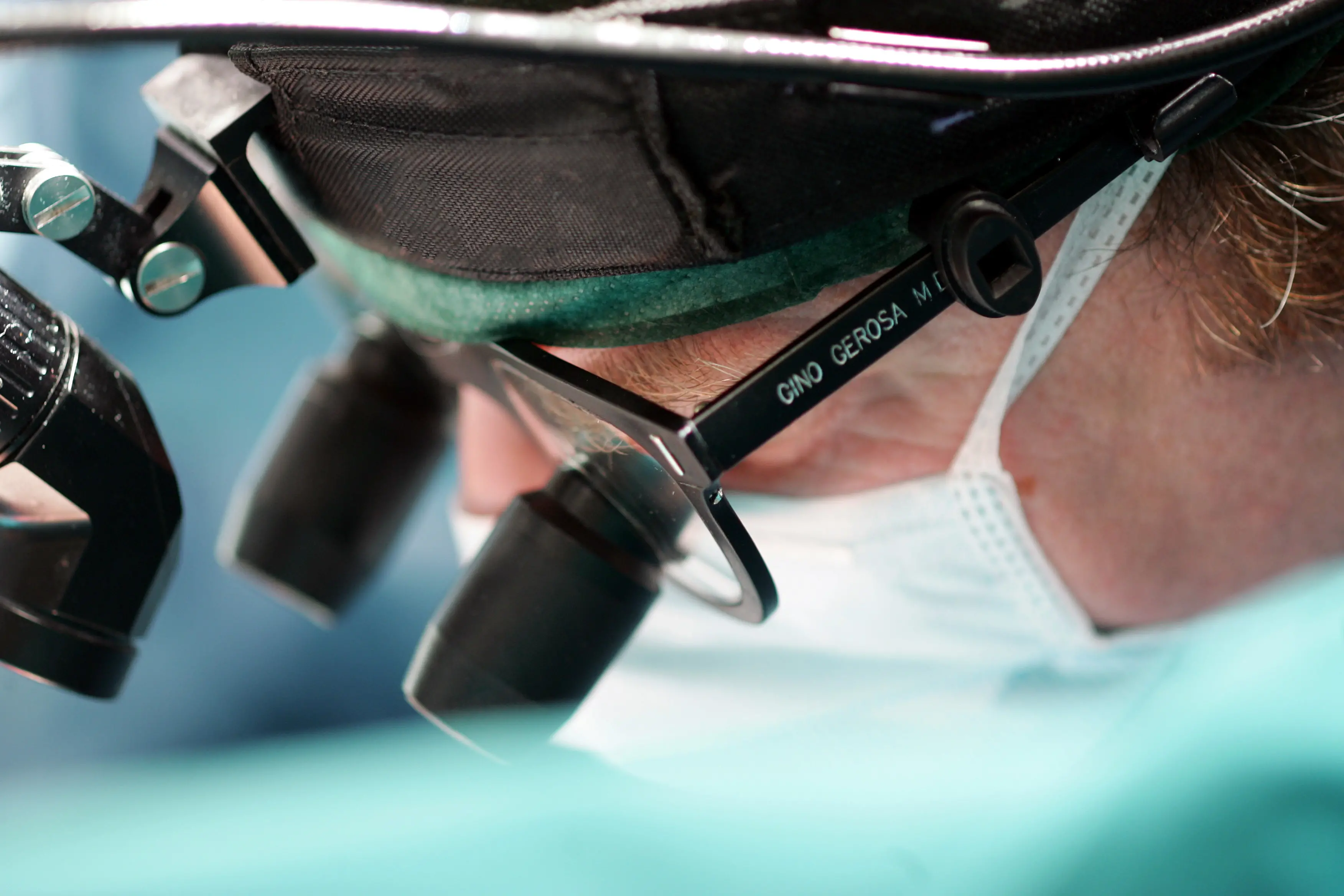 Gino Gerosa in sala operatoria con le lenti binoculari chirurgiche. Ha eseguito oltre 7.000 interventi