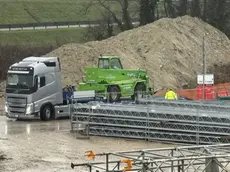 I tir portano via i macchinari dal cantiere della bretella (Foto Porcile)